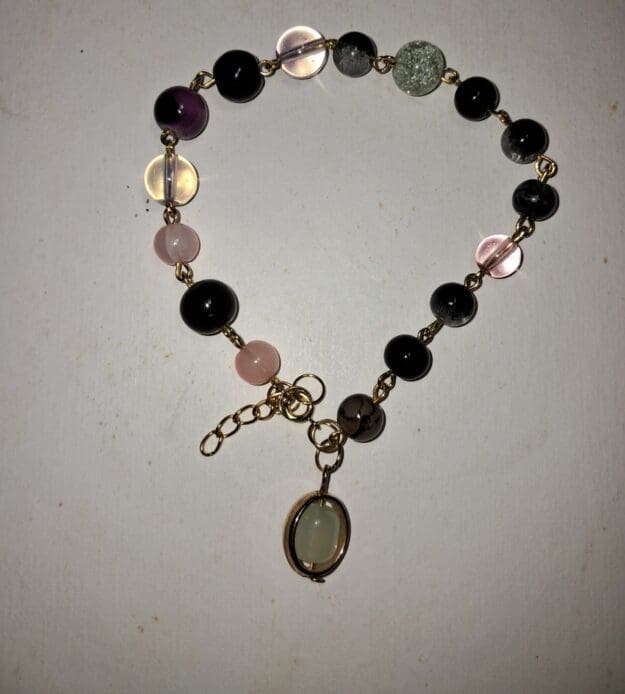 Boho beaded bracelet with spring clasp and oval charm with eclectic gold tone Boho beaded bracelet with spring clasp and oval charm with eclectic gold tone