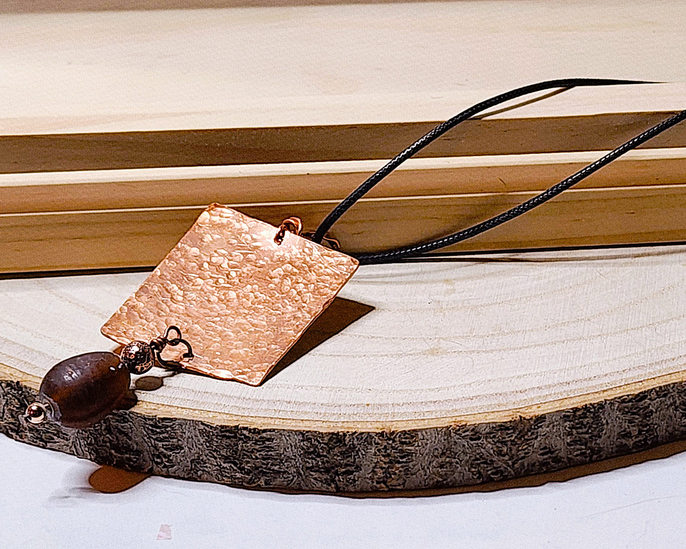 Hammered copper pendant necklace with dark stone accent Hammered copper pendant necklace with dark stone accent
